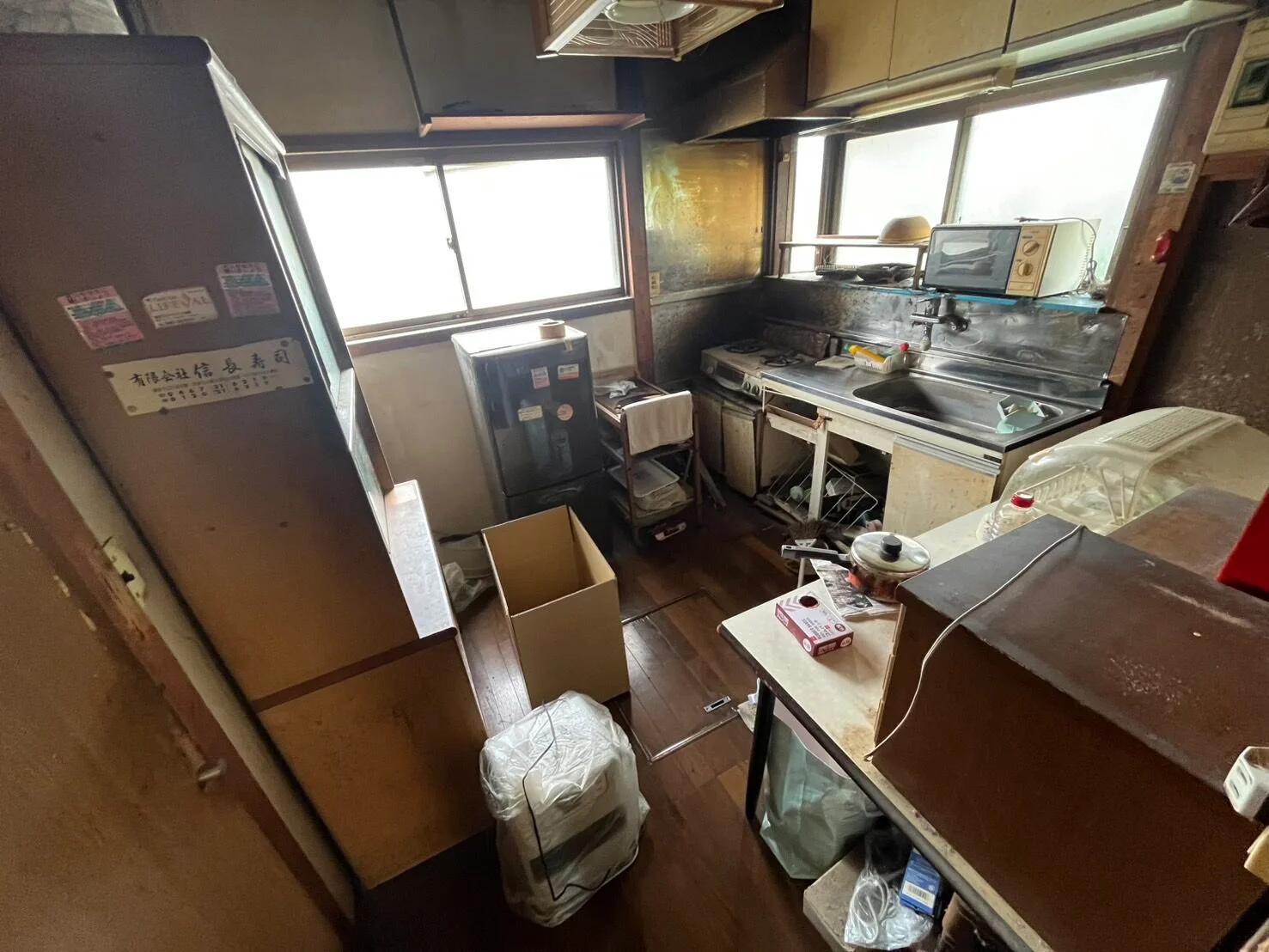 片付け前：冷蔵庫や食器棚、段ボール箱などが置かれた台所